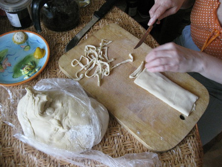 Супруга режет "колбаску" на лапшу.